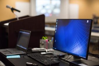 View from stage of an operating computer at the presenter's table next to the podium.